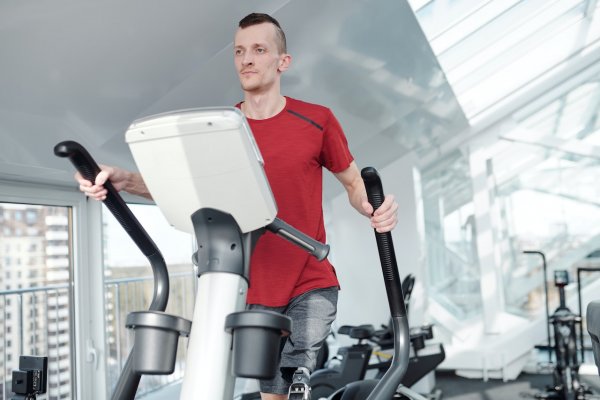 working out on an elliptical trainer in a gym